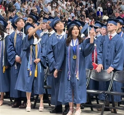graduates from seats waving to audience